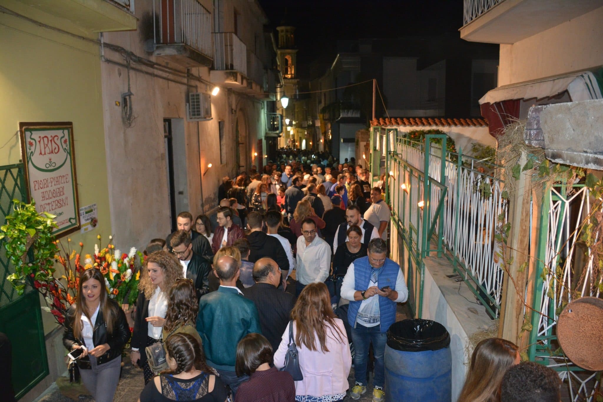 Il vicolo del centro storico pieno di gente durante la sagra, con le luci accese